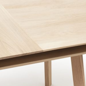 Table repas PARATI. Vue de détail sur le plateau en chêne massif et la rallonge.