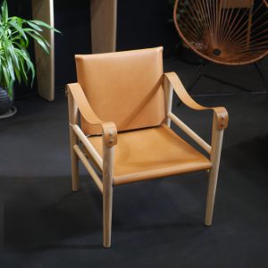 fauteuil safari cuir et bois, sur fond noir. En version cuir miel. Temps libre